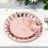Rose gold disposable plate on a table with greenery backdrop.