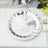 Silver disposable plate with a decorative edge on a table setting.