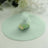 Mint green gift bag filled with assorted candies on a round backdrop.