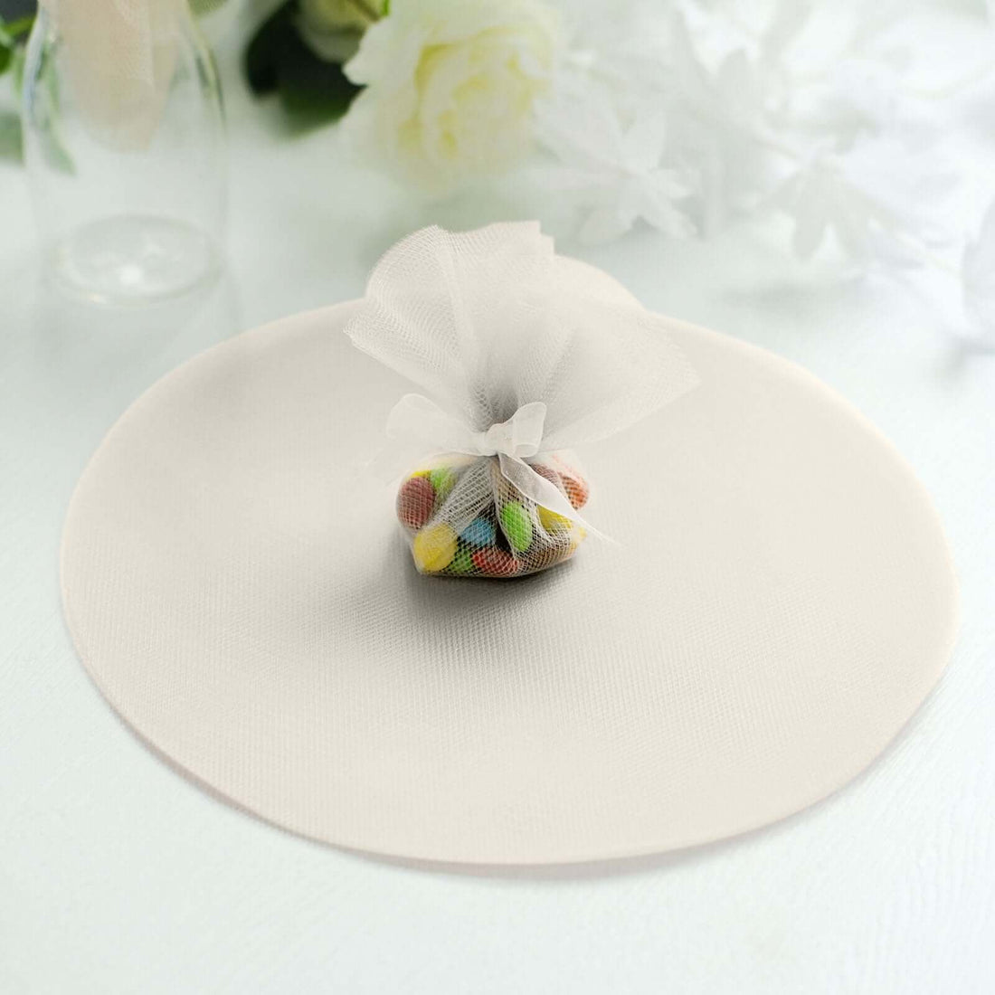 Colorful candy in a mesh bag on a round placemat