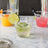 Refreshing cocktails in clear glasses with fruit garnishes on a marble surface.