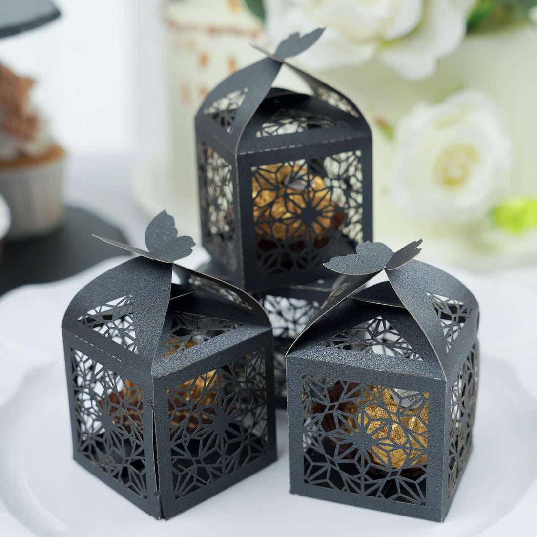 Decorative black lantern boxes with intricate cutout designs.
