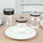 Clear drinking glasses with black rims on a white plate.