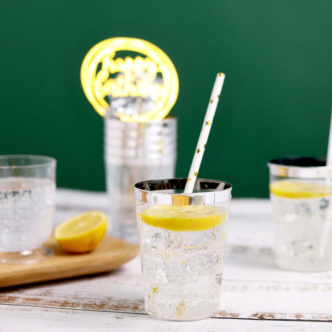 Clear glass with lemon slice and straw, filled with sparkling water.