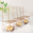 Three transparent chairs with gold accents and chocolates inside, styled on a soft, fluffy surface.