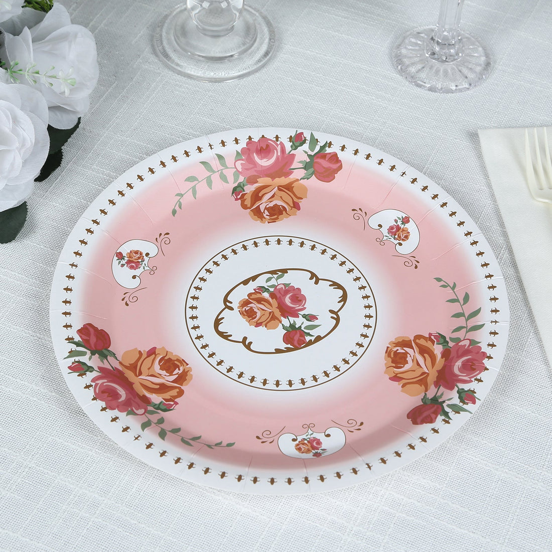 Pink floral plate with rose design and gold accents on a white background.