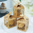 Gold decorative gift boxes with intricate designs on a white plate.