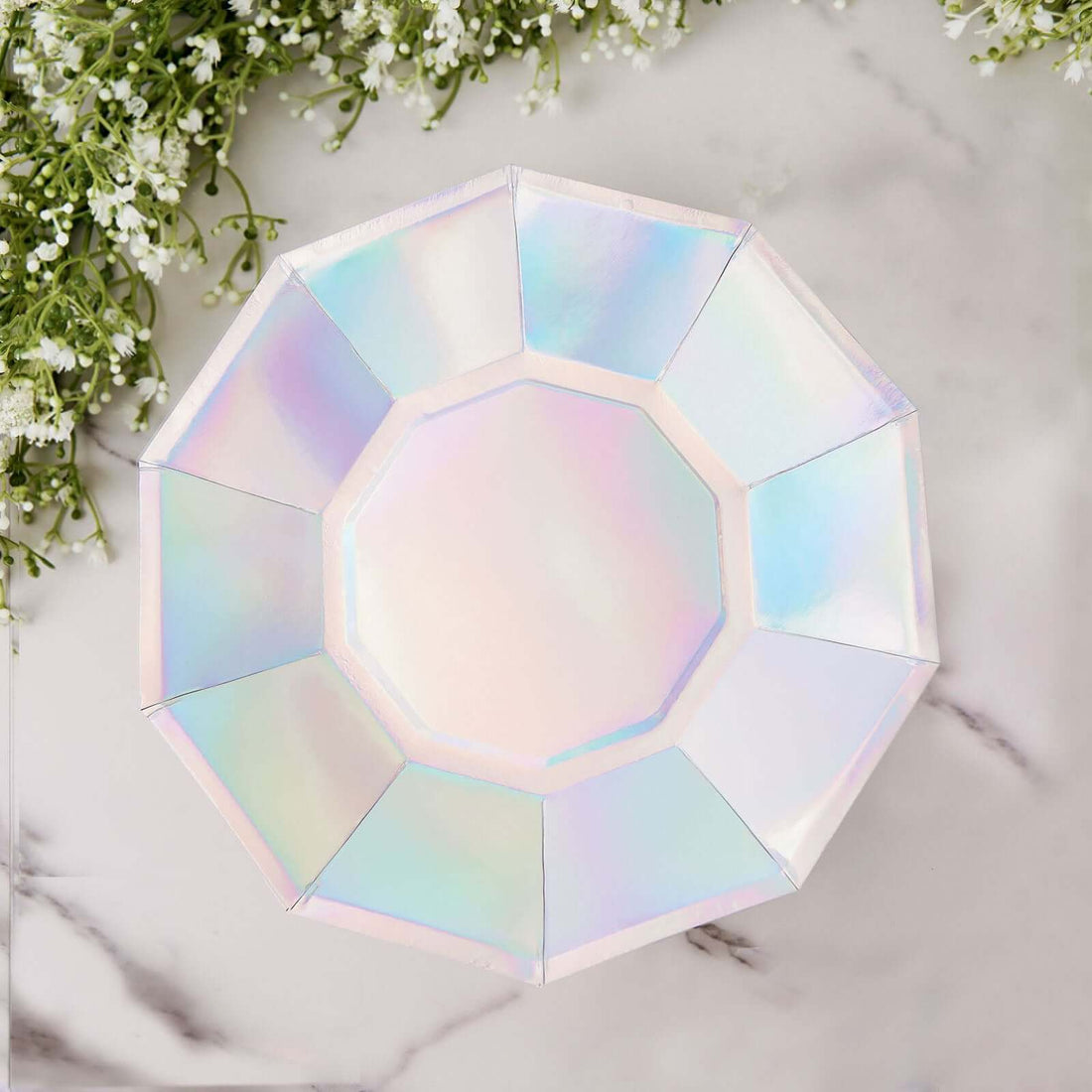 Iridescent octagonal plate on a marble surface with floral accents.