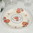 Decorative floral dinner plate with rose design on cream background.
