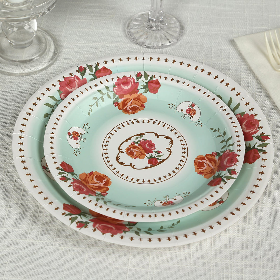 Floral patterned dinner plates stacked on a table setting.
