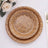 Woven wooden plates stacked together on a light surface.