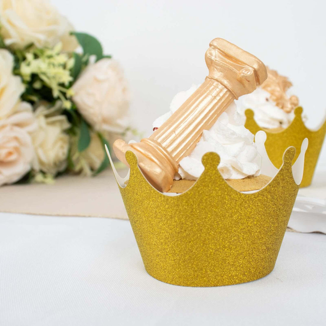 Gold crown cupcake wrapper with a golden trophy on whipped cream topping.