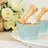 Cupcakes with gold column toppers in decorative blue wrappers.