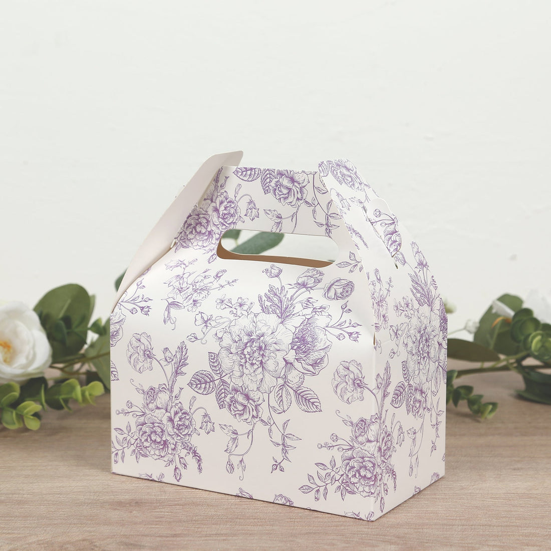 Decorative floral gift box with a handle and cutout design.
