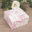Floral patterned gift box on wooden surface with greenery