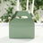 Green takeaway box with handle on a table setting.