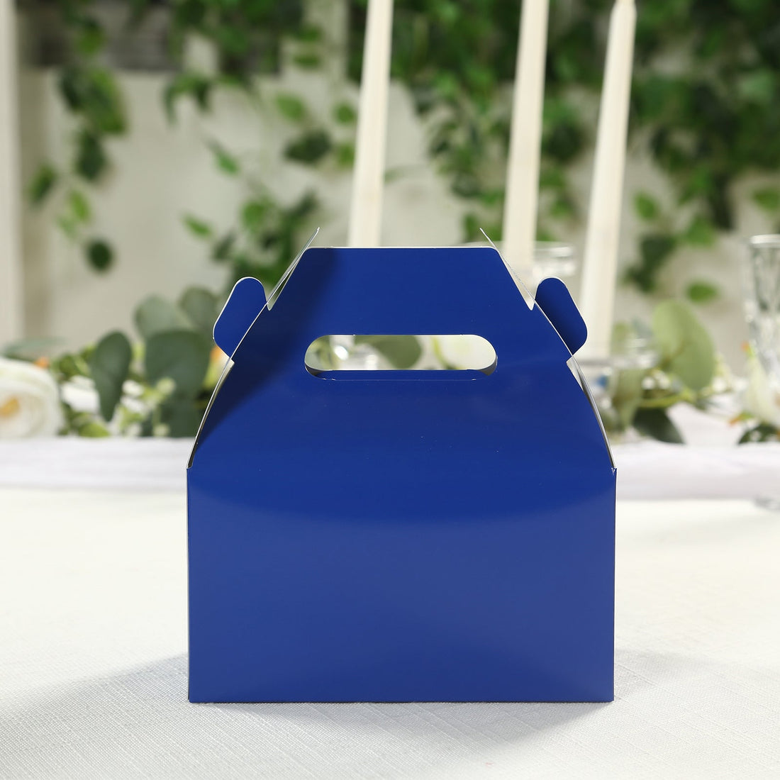 Blue takeaway box with handle on a table setting.