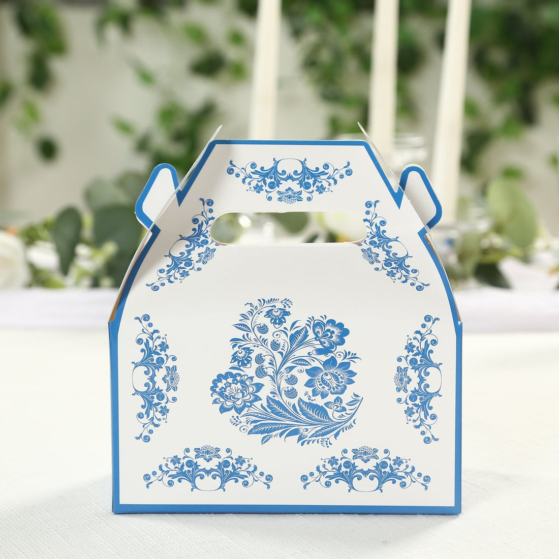 Decorative floral takeout box with blue design on white background.