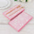 Pink floral patterned napkins with gold fork and knife on a wooden table.