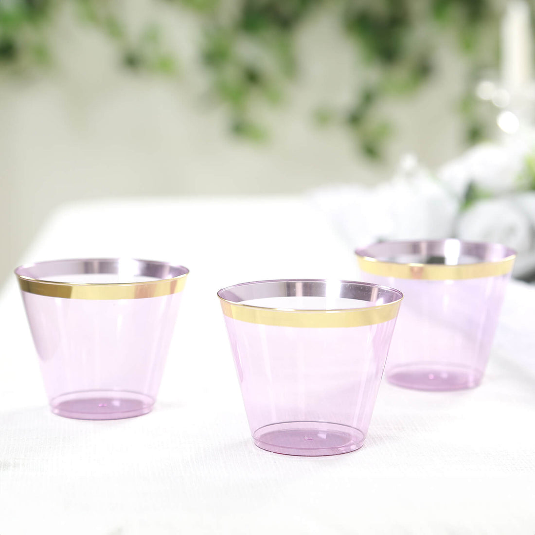 Set of three elegant purple plastic cups with gold rims.
