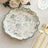 Floral decorative plate with scalloped edge and green trim on a table setting.