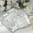 Elegant silver serving platters with intricate designs on a neutral table setting.