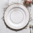 Elegant white plate with gold trim on decorative silver charger.