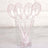 Clear plastic spoons with pink glitter in a cup