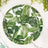 Green tropical leaf patterned plate on a marble surface.