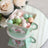 Pastel-colored candy balls in decorative cup on mirrored surface.