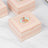 Decorative pink gift box with floral design and ornate edges.