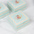 Decorative floral storage box with mint green design and orange accents.