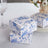 Decorative floral gift boxes stacked on a table.