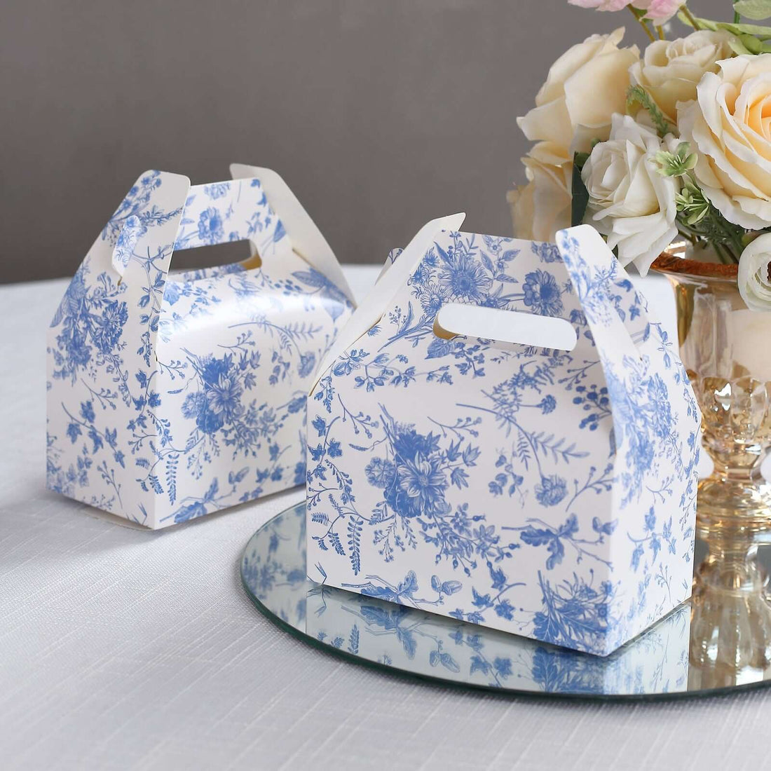 Floral printed gift boxes on a reflective surface.