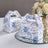 Floral printed gift boxes on a reflective surface.