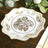 Elegant gold floral design plate on wooden table.