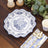 Elegant blue and white floral dinner plate on a wooden table setting.