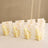 Gold-embellished gift bags with rose design displayed in a row.