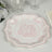 Elegant pink floral patterned plate on a textured table setting.