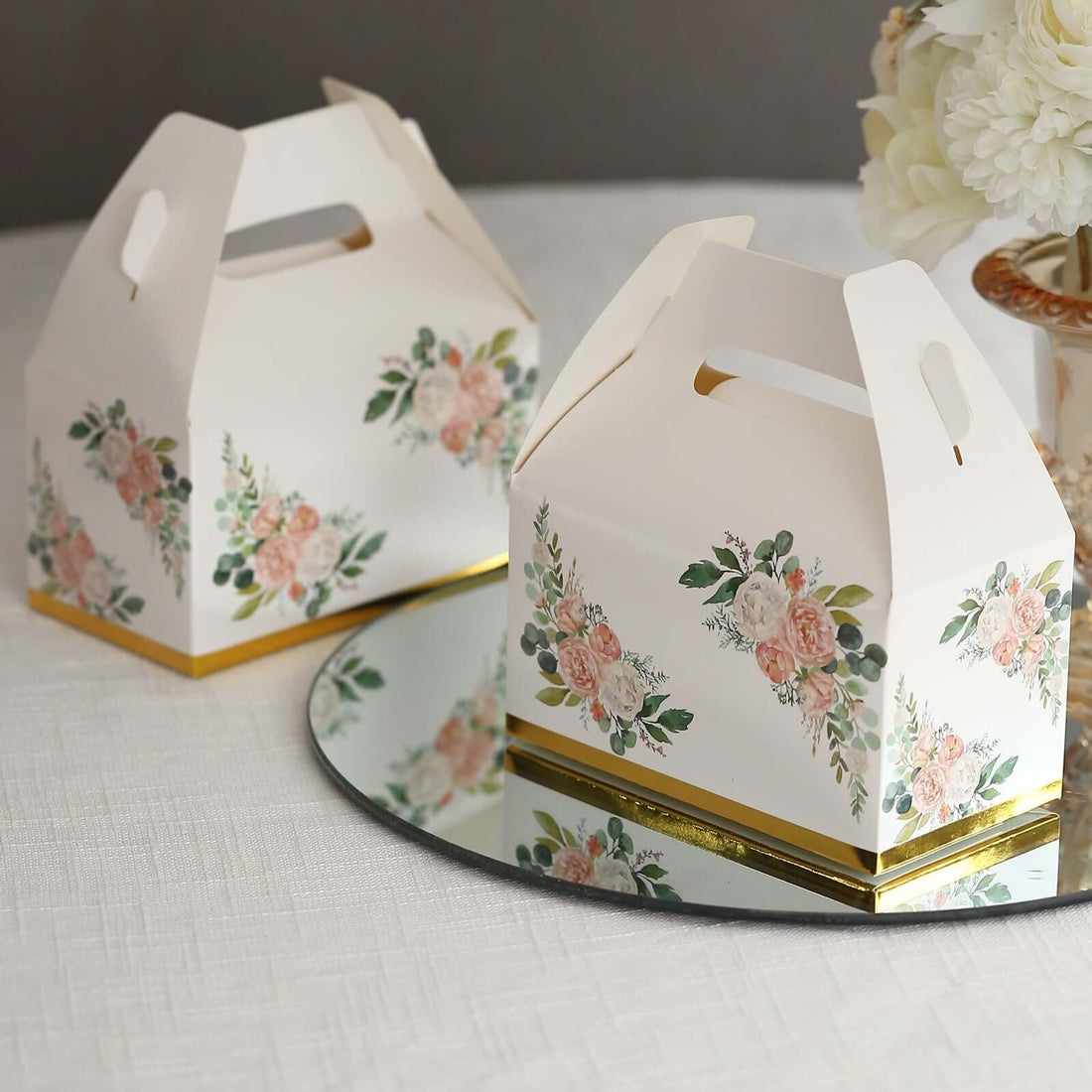 Floral patterned gift boxes on a mirrored surface.