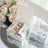 Pastel-colored candy in a decorative floral box on a mirrored surface.