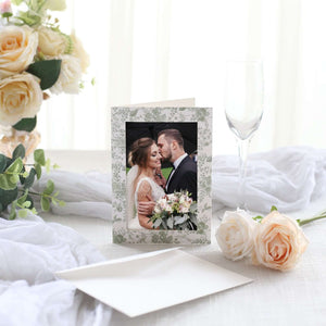 Wedding card with floral design featuring a couple's photo, surrounded by decorative elements.