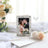 Wedding card with floral design featuring a couple's photo, surrounded by decorative elements.