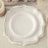 Elegant white plate with silver trim on a soft surface.