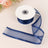 Navy blue sheer ribbon on a spool with a flowing tail