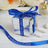 Personalized silver gift box with blue ribbon and custom text.