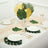 Tropical table setting with green and gold leaf decor and elegant dinnerware.