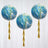 Colorful marbled balloons with gold tassels hanging against a white backdrop