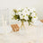 White rose bouquet in a clear vase on a beautifully set dining table.