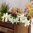 Colorful artificial succulent arrangement in a wooden crate.